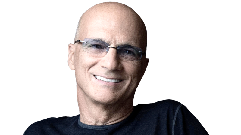Jimmy Iovine wearing a dark T-shirt and glasses while smiling.